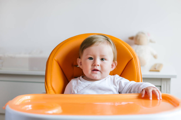 Baby girl sitting in high chair ready to eat - Fotoğraf, Görsel