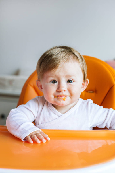 Bébé fille assis dans la chaise haute et manger
 - Photo, image