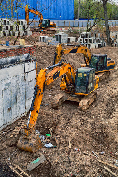 Желтые экскаваторы копают землю. Строительная площадка
 - Фото, изображение