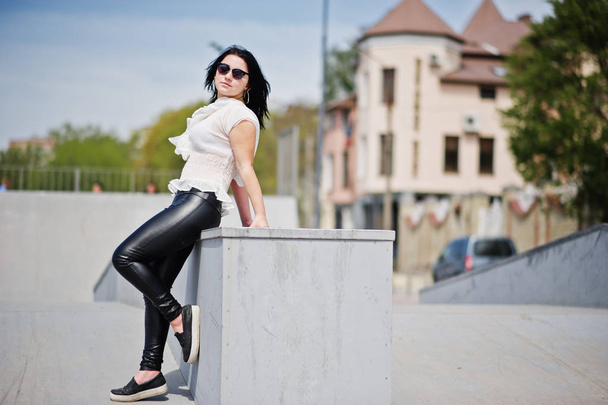 Brunette girl on women's leather pants and white blouse, sunglas - Fotoğraf, Görsel