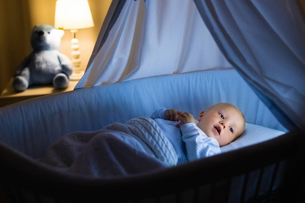 Babyjongen consumptiemelk in bed - Foto, afbeelding