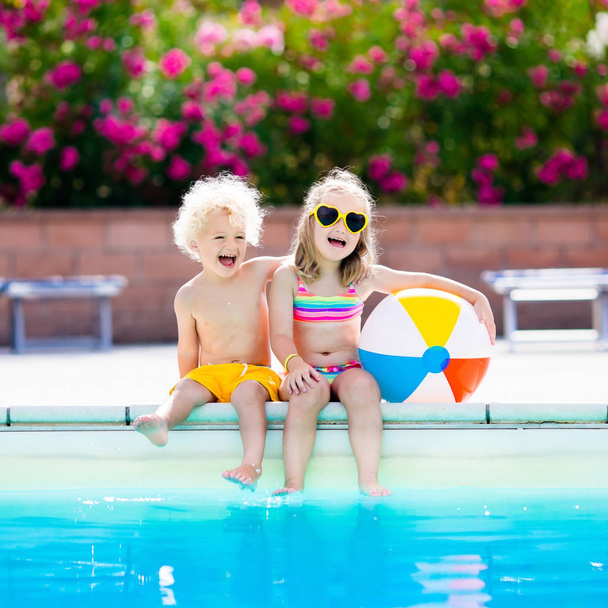 Kinderen spelen bij buitenzwembad - Foto, afbeelding