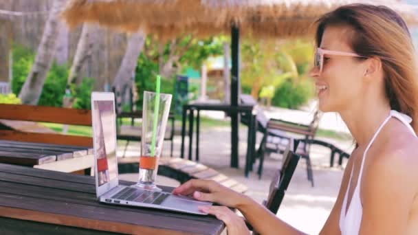 woman sitting on the beach and video chatting - Video, Çekim