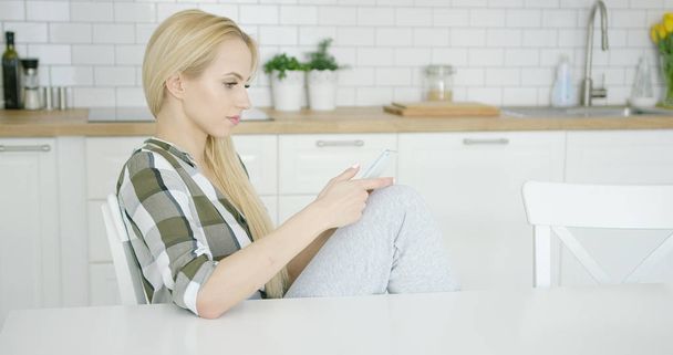 Woman using phone at home - Photo, Image