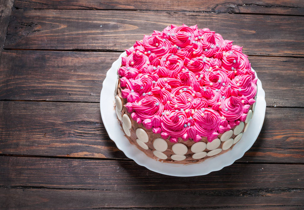 Ciasto z różowy krem na białym tle drewna. Różowy tort. - Zdjęcie, obraz