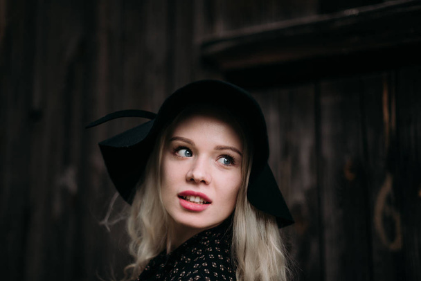 Привлекательная и стильная девушка в черной шляпе, позирующая в городе. Обнаженный макияж, лучшая ежедневная прическа и великолепный стиль кантри моды
. - Фото, изображение