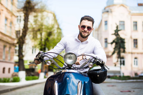 Handsome young man while sitting on scooter - Фото, зображення