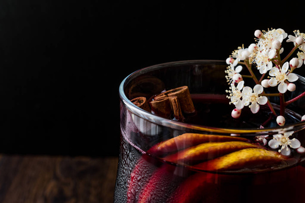 Σαγκρία κοκτέιλ στο ποτήρι κρασιού με λεμόνι, κανέλα, φρούτα και παγωτό. - Φωτογραφία, εικόνα
