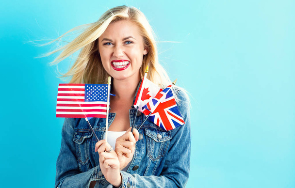  Woman with flags of English speaking countries - 写真・画像