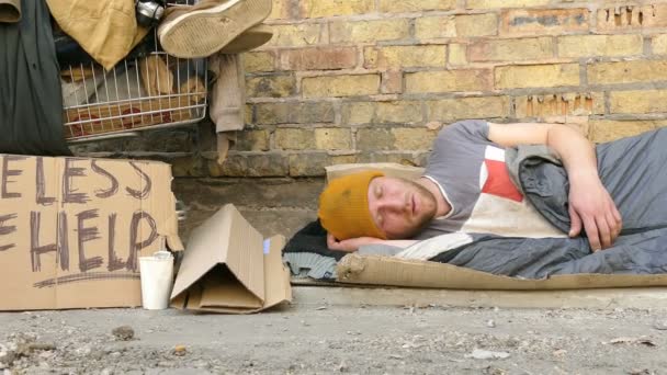  4K. Hombre mendigo sin hogar con carro de dormir cerca de la pared. Slider disparar
  - Metraje, vídeo