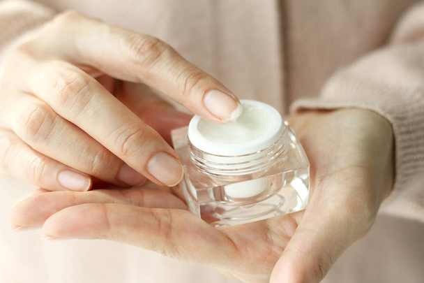 Beauty woman holding a cosmetic bottle containers of skin cream. - Photo, Image