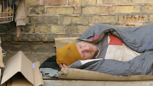  4 k. ホームレスの男性運送睡眠の壁の近くで。ドリー撮影クローズ アップ - 映像、動画
