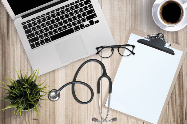Doctor desk table with stethoscope, Laptop computer and eyeglasses, Top view - Photo, image