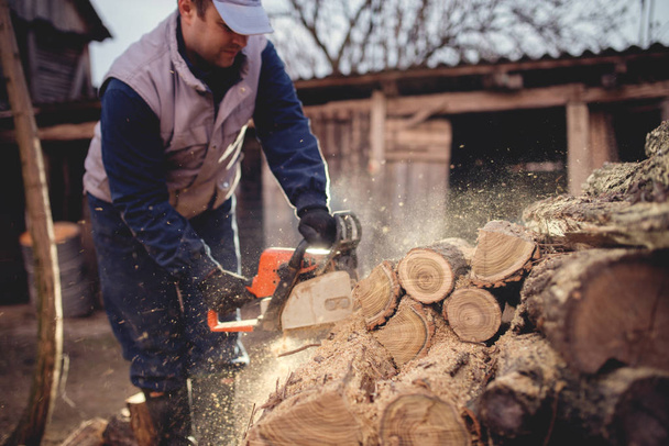 man cutting wood with chainsaw - Фото, зображення
