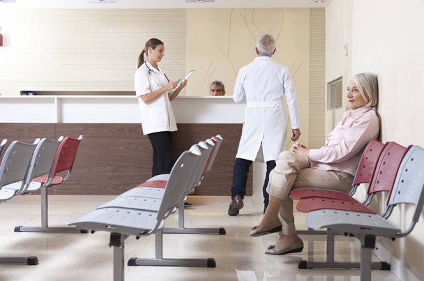 Médicos y pacientes discutiendo en la sala de espera del hospital
 - Foto, imagen
