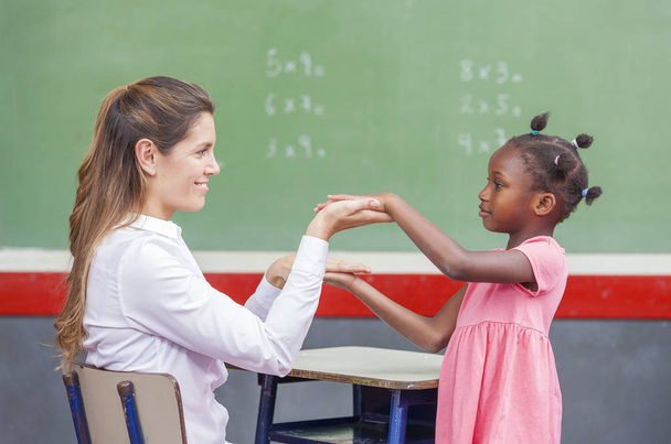 Nauczycielka z afrykańskiego dziecka na tablicy. Koncepcja szkoły - Zdjęcie, obraz