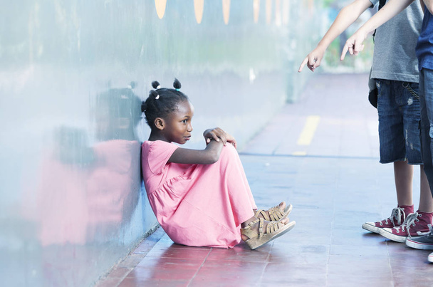 Smiling african schoolgirl alone in a school corner. Bullying co - Photo, Image