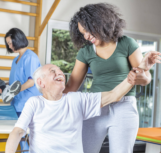 Yaşlı insanlar jimnastik yardım o ile yapım rehabilitasyon Kliniği - Fotoğraf, Görsel