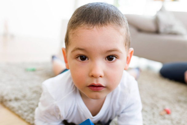 Beatiful young boy looking at camera at home. - Foto, afbeelding