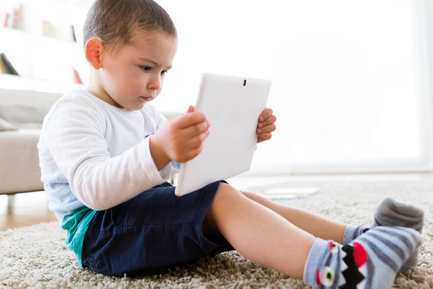 Beautiful young boy using his digital tablet at home. - Valokuva, kuva