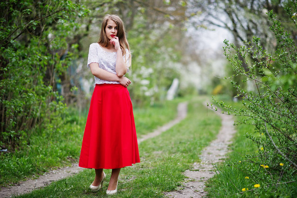 Portrait of beautiful girl with red lips at spring blossom garde - Valokuva, kuva
