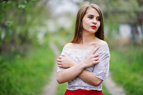 Portrait of beautiful girl with red lips at spring blossom garde - Foto, Imagem