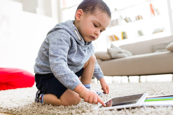 Beautiful young boy using his digital tablet at home. - Photo, image