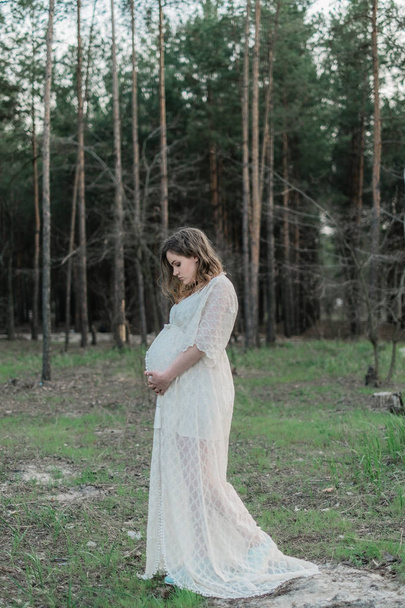 pregnant woman on lawn in forest - Zdjęcie, obraz