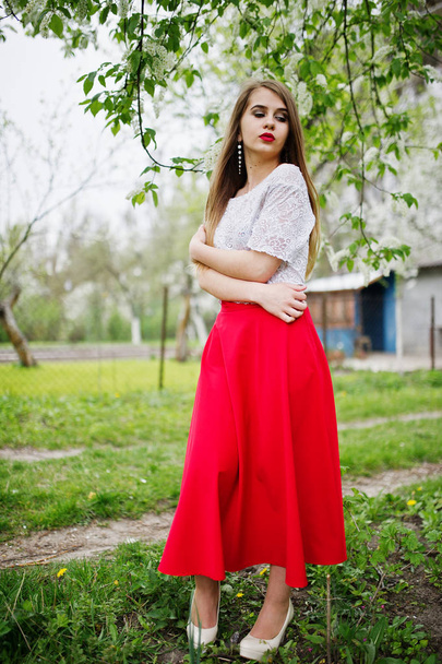 Portrait of beautiful girl with red lips at spring blossom garde - Φωτογραφία, εικόνα