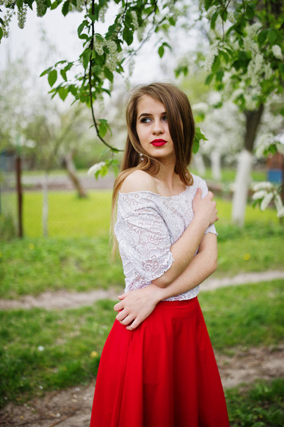 Portrait of beautiful girl with red lips at spring blossom garde - Zdjęcie, obraz