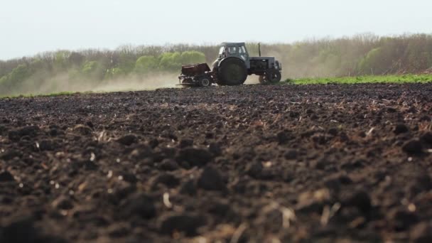 Farmář výsevu zoraného pole s traktorem - Záběry, video