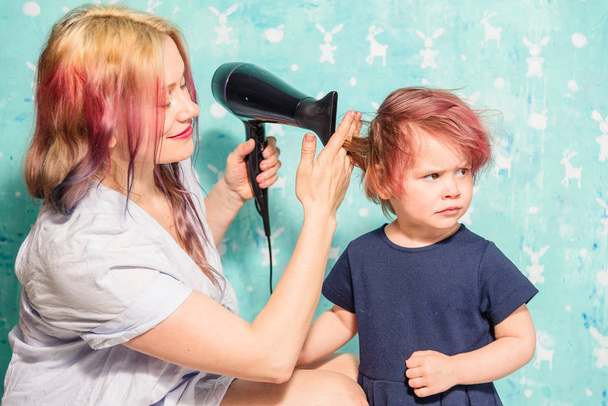 Äiti kuivattaa tyttärensä hiukset
 - Valokuva, kuva