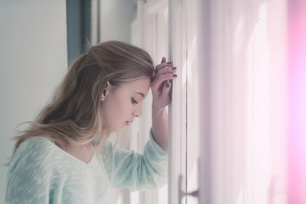 Pretty girl standing at window - Фото, изображение