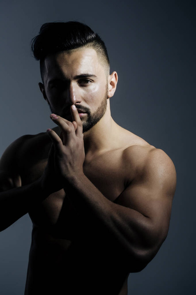 Sexy athletic man posing with muscular hands at handsome face - 写真・画像