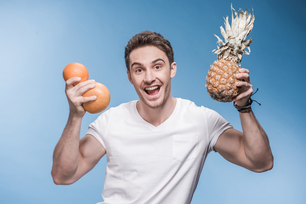 Young man with fruits  - Foto, afbeelding