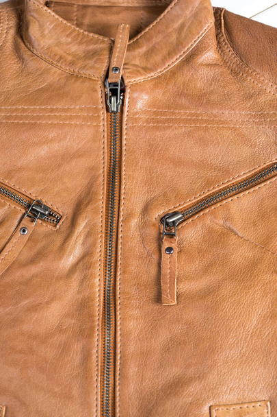 Light brown leather jacket. Beige color leather jacket on hanger. Zippers and details on jacket - Zdjęcie, obraz