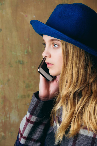 charming young woman in hat speaking on mobile phone - Foto, imagen
