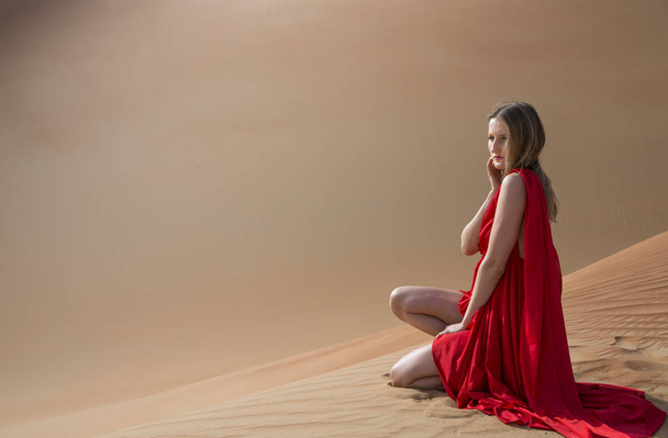 Nainen punaisessa mekossa aavikolla
 - Valokuva, kuva