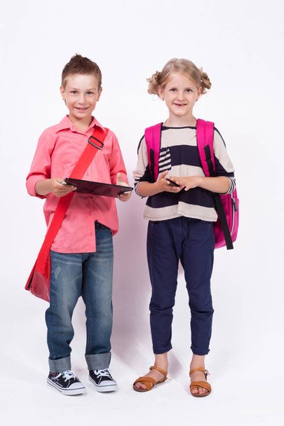 schoolkinderen met de tablet en telefoon - Foto, afbeelding