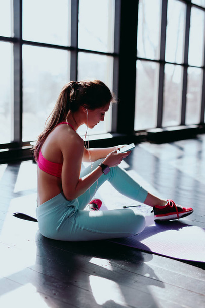 woman using smartphone at gym - Foto, afbeelding