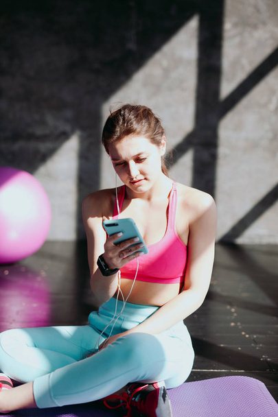 woman using smartphone at gym - Foto, Imagen