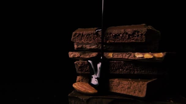 Donkere warme chocolademelk giet neer over chocolade. Slow motion - Video