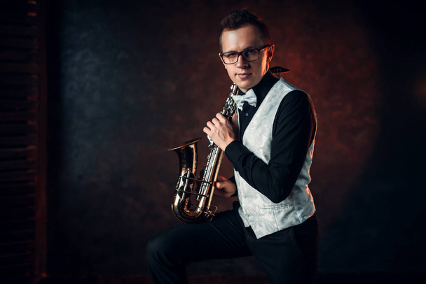 männlicher Musiker posiert mit Saxophon - Foto, Bild