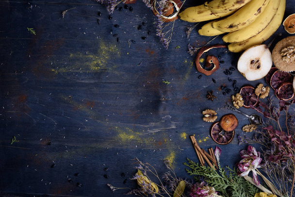 Fruits, spices and nuts on a rustic table. Warm autumn theme. Copy space - Фото, изображение