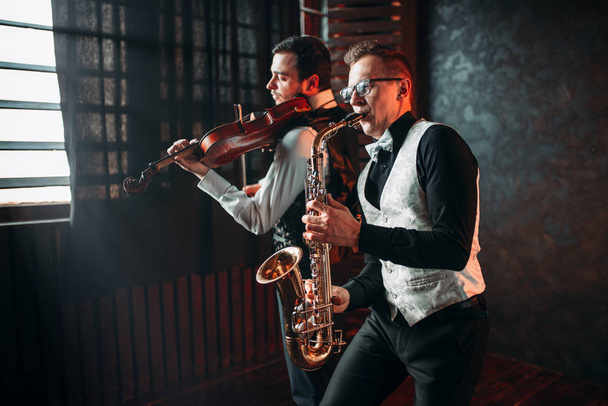 mannelijke muzikanten spelen viool en saxofoon - Foto, afbeelding