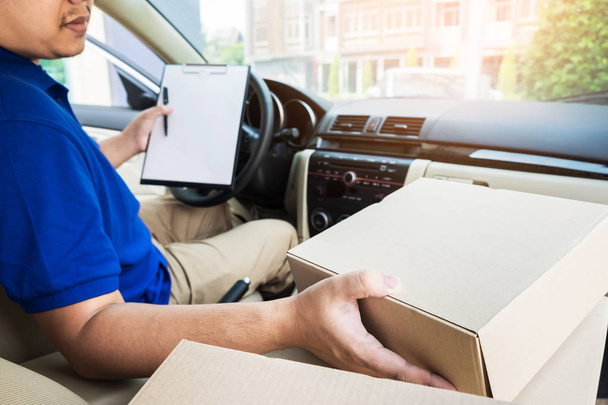 Чоловік доставки з картонною коробкою перевірки списку документів У фургоні a
 - Фото, зображення