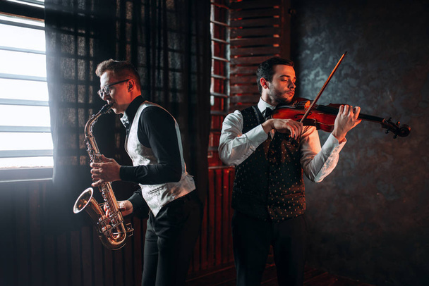 musiciens masculins jouant du saxophone et du violon
 - Photo, image