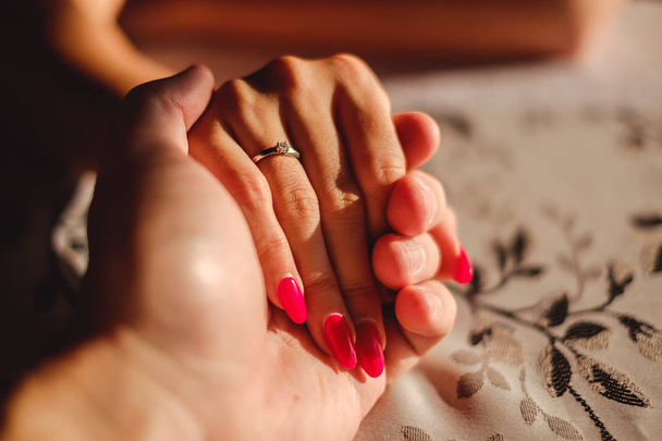 Ο άνθρωπος το χέρι εκμετάλλευση γυναίκας με δαχτυλίδι αρραβώνων στο δάχτυλο - Φωτογραφία, εικόνα
