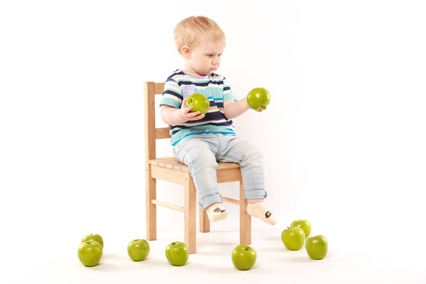 Niño con manzanas verdes
 - Foto, Imagen