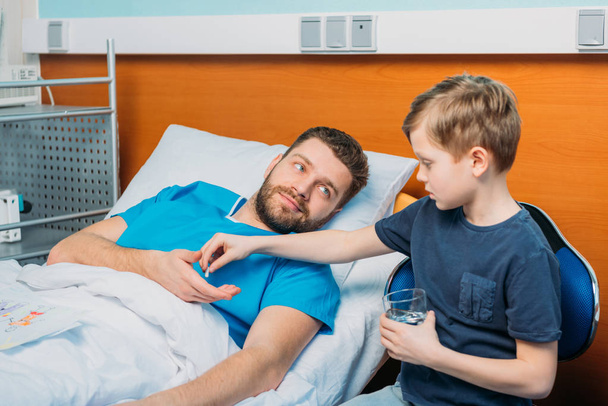 son giving pills to sick father - Photo, Image